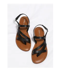 Close-up of black strappy gladiator sandals with brown cushioned insole and buckle