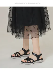 Detail of black wedge sandals with multi-strap leather design and adjustable velcro strap