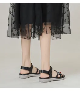 Detail of black wedge sandals with cross straps and adjustable heel hook-and-loop closure