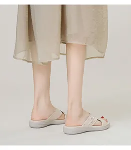 Close-up of beige platform slide sandals with perforated straps and metal buckles