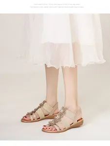 Détail de sandales bohèmes à talons compensés avec brides dorées et fleurs en relief