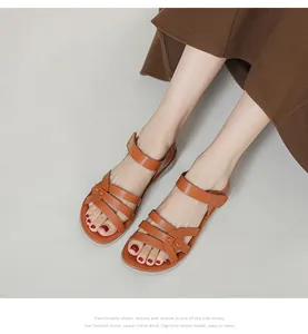 Close-up of caramel brown wedge sandals featuring criss-cross straps and velcro closure