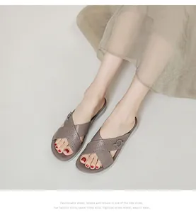 Detailed macro view of laser-perforated taupe leather straps on platform sandals