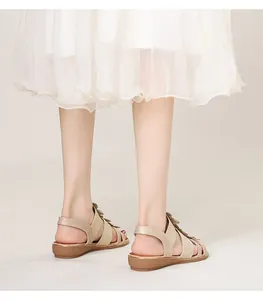 Détail de sandales bohèmes beige avec brides tressées et élégantes décorations florales