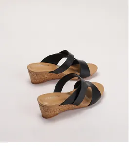 Détail de sandales compensées pour femmes avec brides gaufrées noires et semelle en liège