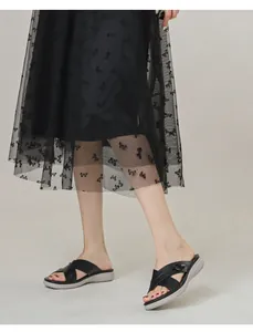 Detail of black cross strap slide sandals with buckle and chunky platform sole