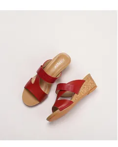 Gros plan de mules à talons compensés rouges avec texture crocodile et aspect liège naturel