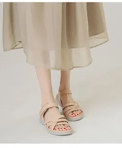 Detail view of khaki wedge sandals with cross straps and adjustable velcro closure