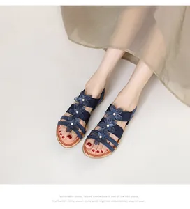 Détail de sandales bohèmes bleu marine avec motifs floraux et perles métalliques