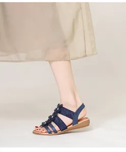 Détail de sandales compensées bohèmes bleu marine avec fleurs et bride élastique