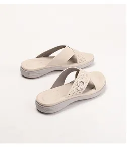 Close-up of beige platform slide sandals with perforated cross straps and buckle detail