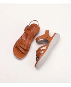 Detail of wedge sandals with crisscross brown straps and thick wave-textured soles