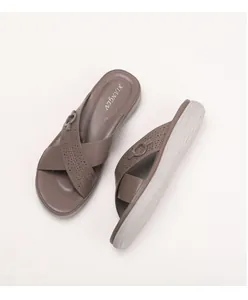 Detail view of taupe wedge sandals featuring perforated crisscross straps and round buckles