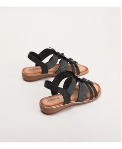 Détail de sandales noires bohèmes avec lanières croisées et accents floraux décoratifs