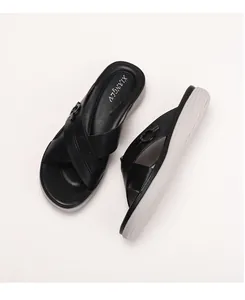Close-up of black leather cross-strap platform sandals with buckle detail and wave sole