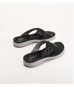 Close-up of black platform sandals with laser-cut straps and metal ring buckle details
