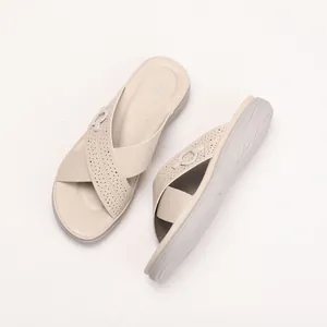 Beige platform slide sandals with crisscross straps and perforated detail for summer wear