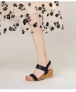 On-foot view of black bohemian wedge sandals with sparkling rhinestones and wood grain heel