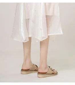 Detail of wedge platform slipper with laser-cut straps and golden metal buckle