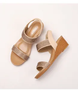 Detail of bohemian wedge sandals featuring champagne gold rhinestone straps and wood texture