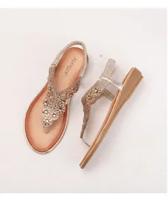 Vue de dessus de tongs compensées dorées avec strass étincelants et perles décoratives