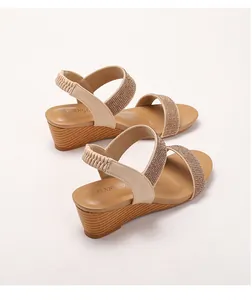 Detail of bohemian wedge sandals with gold rhinestones and wood grain textured heel