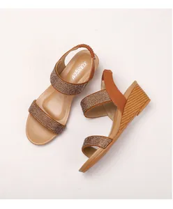 Detail of bohemian wedge sandals with rhinestone straps and brown elastic back strap
