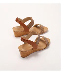 Detail of bohemian wedge sandals with gold rhinestone straps and wood grain texture