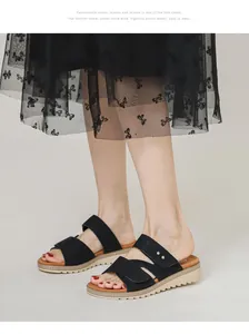 Gros plan sur des mules compensées noires à rivets argentés avec semelle beige crantée
