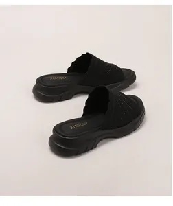Nahaufnahme schwarzer Strick-Keilsandalen mit gewelltem Rand und rutschfester Plateausohle