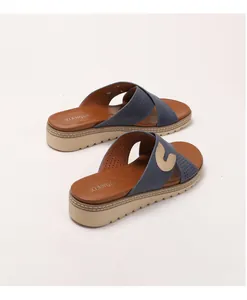 Detail of navy platform wedge slide with gold G buckle and non-slip serrated sole