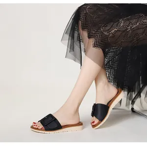 Detalle de sandalias de cuña negras con hebilla y suela gruesa de estilo bohemio