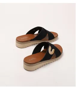 Close-up of bohemian platform flip flops featuring gold metal buckles and brown leather insoles