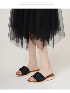 Detalle de sandalias negras con cuña y suela de plataforma dentada y hebilla elegante