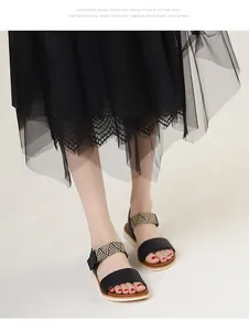 Detail of wedge platform sandals featuring black leather straps and woven bohemian textures