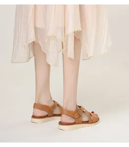 Detail view of brown wedge sandals with crisscross straps and beige platform sole