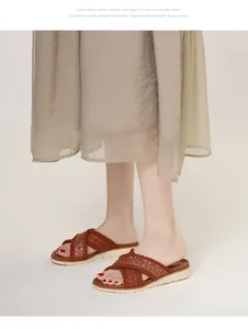 Detail van boheemse wedge slippers met geborduurde kruisbanden en fonkelende strassteentjes