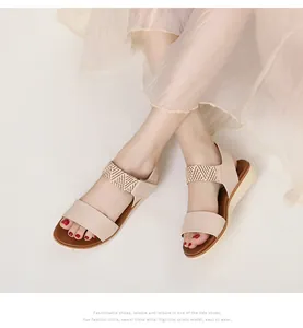 Detail of beige summer wedge sandals showing elastic straps and non-slip sole on foot
