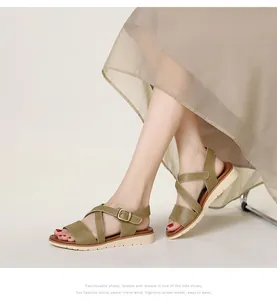 Detail of olive green wedge sandals featuring cross straps and adjustable metal buckle