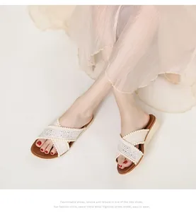 Detailopname van bohemian sleehak sandalen met geborduurde kanten bandjes en weefdetails