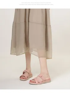 Pink cross strap platform slide sandals worn with beige dress for casual summer style