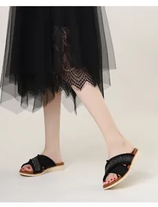 Detail van bohemien sleehak slippers met gekruiste bandjes en glanzende stras