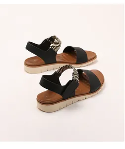 Detail of wedge sandals with black woven straps and textured non-slip comfort footbed