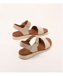 Detail of beige wedge sandals featuring elastic heel strap and textured non-slip footbed