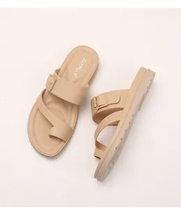 Dettaglio di sandali con zeppa beige, design a doppia fascia e suole in gomma antiscivolo