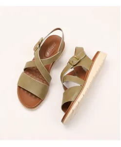 Close-up of olive green crossover straps and golden buckle on wedge sandals
