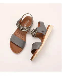Close-up of wedge sandals featuring ethnic woven ankle straps and massage-dot footbed