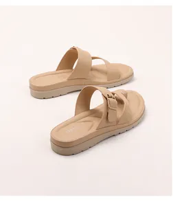 Dettaglio di sandali con zeppa beige con fibbie in metallo regolabili e suole antiscivolo
