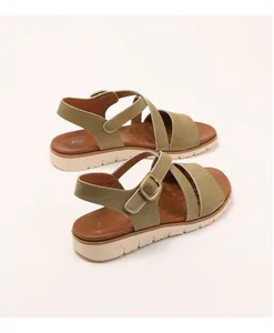 Detailed view of women's wedge sandals with olive green cross straps and metal buckle