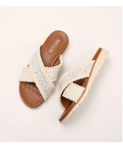 Detail van Boheemse sleehak slippers met borduursels en kralen op de gekruiste bandjes